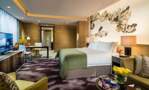 a hotel room with a bed and a living room at Four Seasons Hotel Shenzhen in Shenzhen