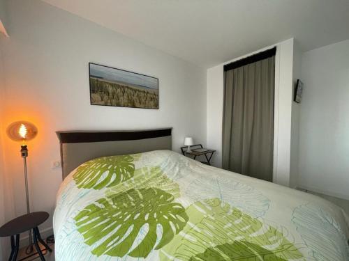 une chambre avec un lit avec une couette verte dans l'établissement Appartement T2 avec terrasse proche centre et plage d'Arcachon - FR-1-474-230, à Arcachon