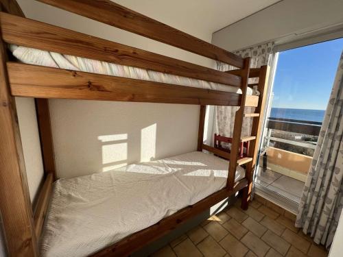 1 Schlafzimmer mit 2 Etagenbetten und einem Balkon in der Unterkunft Studio Cap d'Agde, 1 pièce, 4 personnes - FR-1-702-26 in Cap d'Agde