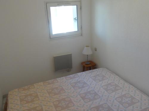 une chambre avec un lit et une fenêtre dans l'établissement T2 avec loggia vitrée proche plage, climatisé, vue marina - FR-1-472-173, à Sète