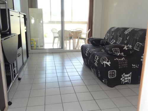 - un salon avec un canapé et du carrelage dans l'établissement T2 avec loggia vitrée proche plage, climatisé, vue marina - FR-1-472-173, à Sète