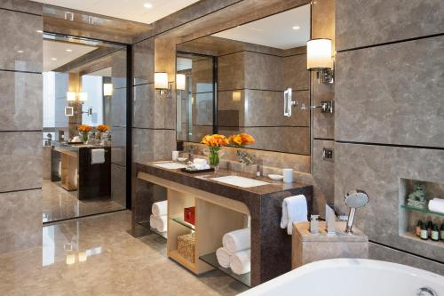 a bathroom with two sinks and a large mirror at Four Seasons Hotel Shenzhen in Shenzhen