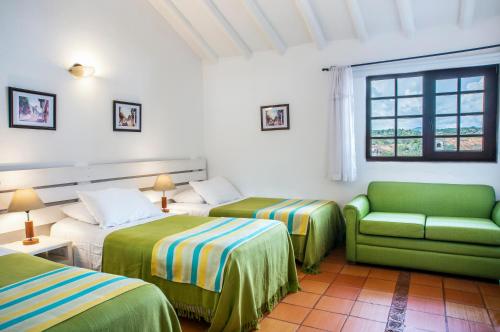 a hotel room with two beds and a couch at Hotel y Spa Getsemani in Villa de Leyva