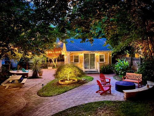 a yard with a house with a blue roof at The Cozy Yellow Cottage in Dilworth in Charlotte