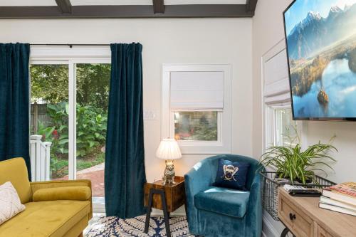 a living room with a couch and a tv at The Cozy Yellow Cottage in Dilworth in Charlotte