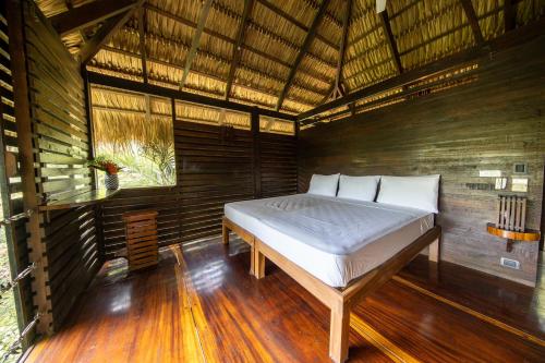 a bedroom with a bed in a wooden room at Buena Vista Surf Club in Playa Maderas