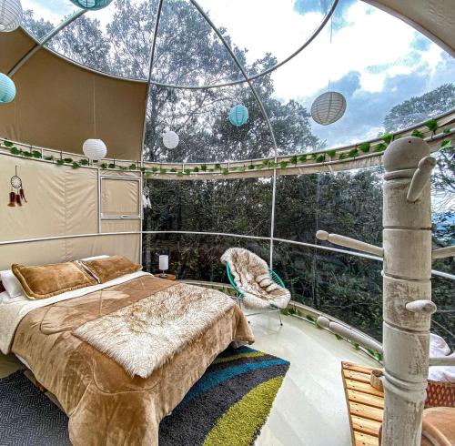 um quarto num barco com uma cama e uma janela em Cumbre Glamp em Tocancipá