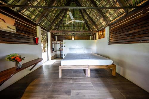a bedroom with a bed and a wooden ceiling at Buena Vista Surf Club in Playa Maderas