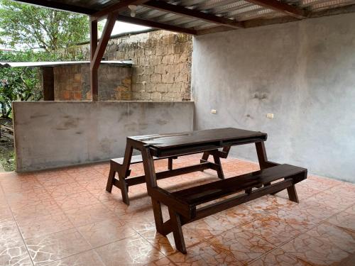 una mesa de picnic y un banco en un patio en MY HOUSE IN MACAS, MIRADOR AL UPANO, en Macas