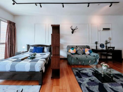 ein Schlafzimmer mit einem Bett und einem Sofa in der Unterkunft Regalia Residence The Sky Pool Suite in Kuala Lumpur