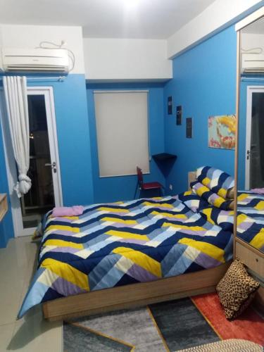 a bedroom with a blue and yellow striped bed at Adits in Karawang