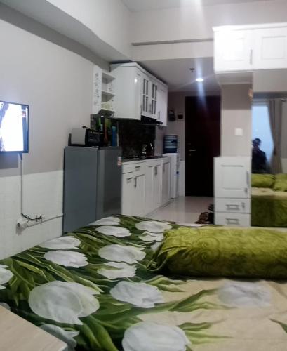 - une chambre avec un lit orné de fleurs blanches dans l'établissement Adits, à Karawang