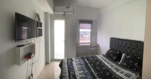 a bedroom with a bed and a flat screen tv at Adits in Karawang