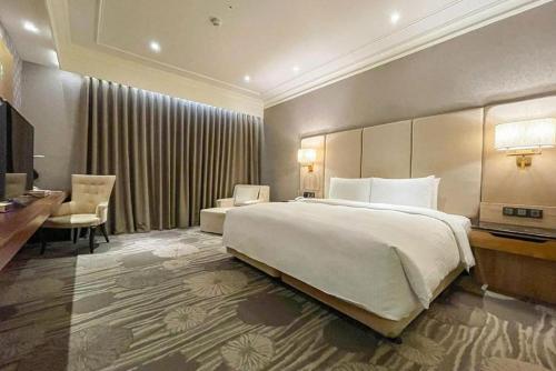 una camera d'albergo con un grande letto e una scrivania di CHECK inn Select Tainan Yongkang a Yongkang