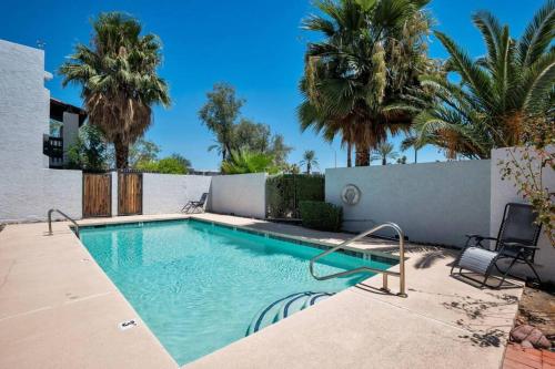 a swimming pool in a yard with palm trees at Heart of Old Town Scottsdale in Scottsdale