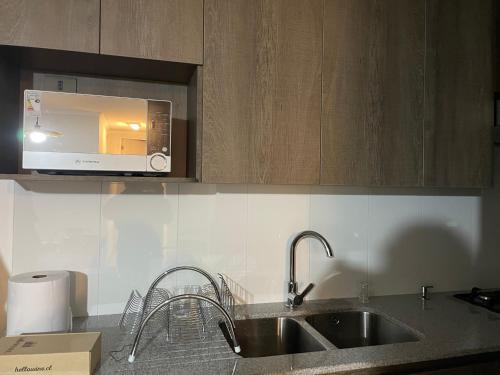 a kitchen with a sink and a microwave at Departamento con vista al mar in Iquique