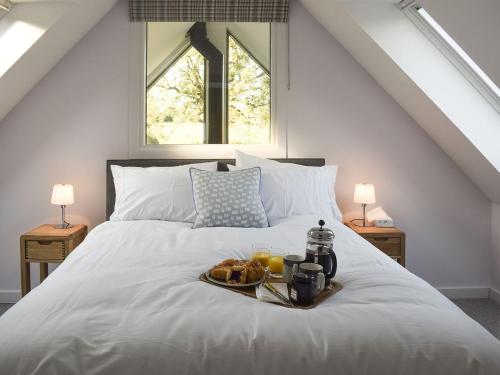 a tray of food on a bed with two windows at Rowanlea in Muthill