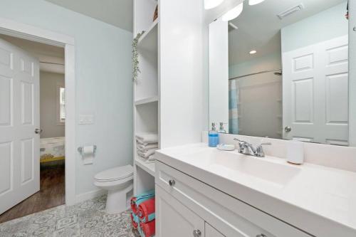 a white bathroom with a sink and a toilet at Stylish 2 bedroom home close 2 dtown, nas, and bch in Pensacola