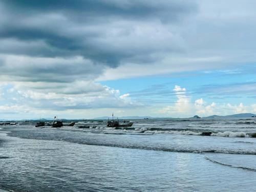 a beach with waves and boats in the water at Khách sạn Đại Dương Diễn Châu - Nghệ An in Diễn Châu