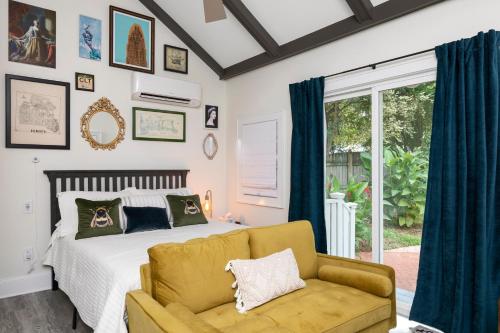 um quarto com uma cama, um sofá e uma janela em The Cozy Yellow Cottage in Dilworth em Charlotte