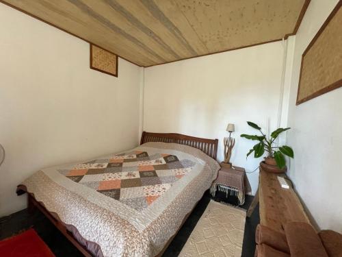 a bedroom with a bed with a quilt on it at Monsonkeang Camping view ม่อนสันเกี๋ยง in Mae Chaem