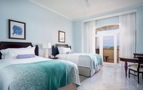 um quarto com 2 camas, uma secretária e uma janela em Ritz Carlton Club, St, Thomas - 2BR Luxury oceanfront villa! condo em Nazareth