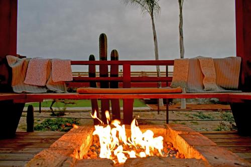 een vuurplaats met een bank en stoelen ernaast bij Vides del Rio Suites in Valle de Guadalupe