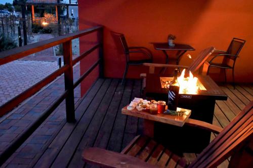 a wooden deck with a table and chairs on a balcony at Vides del Rio Suites in Valle de Guadalupe