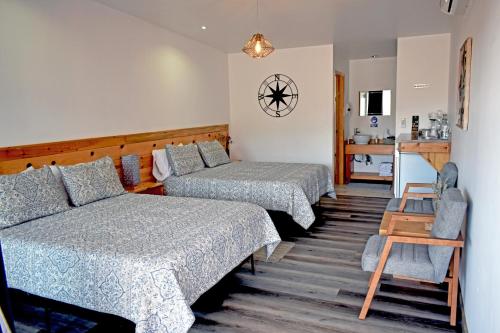 a hotel room with two beds and a kitchen at Vides del Rio Suites in Valle de Guadalupe