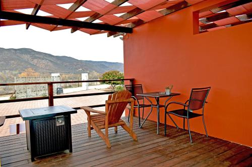 a patio with a table and chairs on a deck at Vides del Rio Suites in Valle de Guadalupe