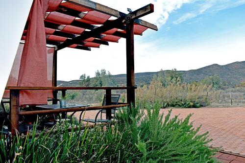 a patio with a table and a umbrella at Vides del Rio Suites in Valle de Guadalupe