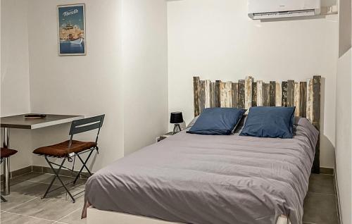 een slaapkamer met een bed met blauwe kussens en een bureau bij Gorgeous Apartment In Ginasservis With Wifi in Ginasservis