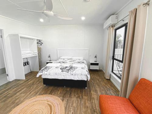ein Schlafzimmer mit einem Bett, einem Fenster und einem Sofa in der Unterkunft Warrego Hotel Motel Cunnamulla in Cunnamulla