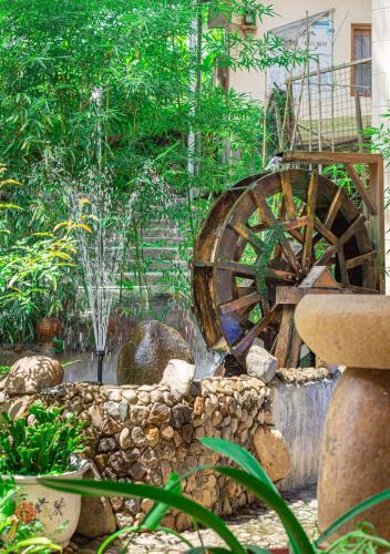 a garden with a water fountain and a wooden wheel at Nanjing Tulou Xinyuan HomeStay in Nanjing