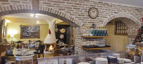 a room with a brick wall with a clock on the wall at Archontiko Art Hotel in Galaxidhion
