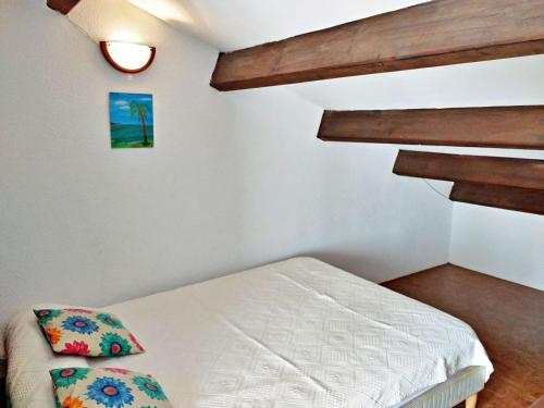 um pequeno quarto com uma cama e uma escada em Appartement Marseillan-Plage, 2 pièces, 6 personnes - FR-1-387-48 em Marseillan
