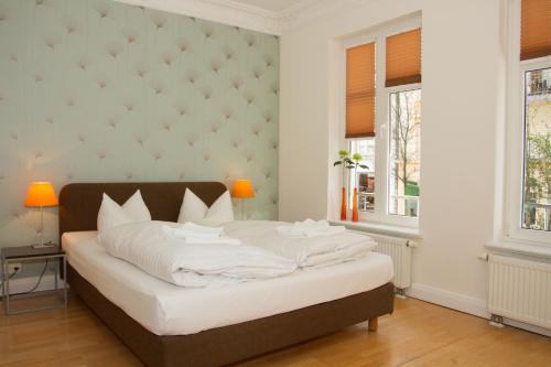 a bedroom with a large bed and two windows at Schlaflounge in Hamburg