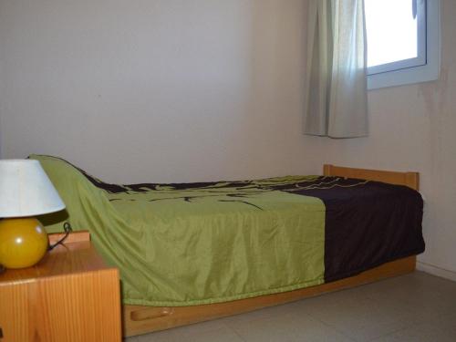 une chambre avec un lit avec une couette verte dans l'établissement Appartement cosy pour 4 avec balcon et cuisine équipée - FR-1-593-37, aux Angles