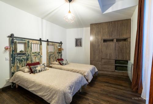 een slaapkamer met 2 bedden en een houten kast bij Appartement Grenat Bourg d'Oisans in Le Bourg-dʼOisans