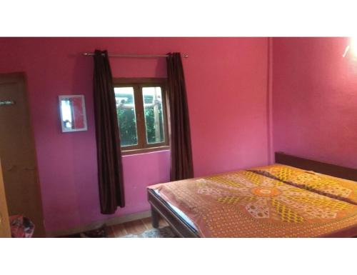 1 dormitorio con cama y ventana en Silent Valley Resort,Lamagaon, en Bijanbāri Bāzār