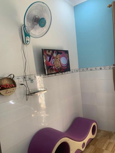 a bathroom with a purple guitar in front of a fan at Hoàng Nam Hotel Bình Dương in Tân Uyên