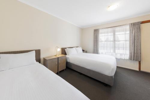 a hotel room with two beds and a window at Best Western Olde Maritime Motor Inn in Warrnambool