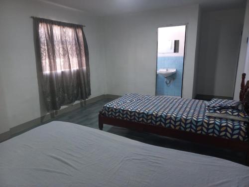 a bedroom with two beds and a sink and a mirror at Habitaciones Grupales in Playas