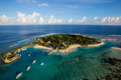 an island in the ocean with boats in the water at Holiday Inn Resort Kandooma Maldives - Kids Stay & Eat Free and Free Roundtrip Speed Boat for a minimum 4 nights stay in Guraidhoo