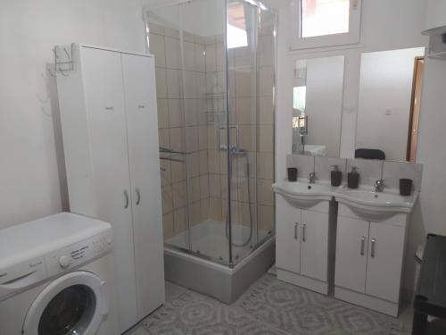 une salle de bain avec douche et lavabo et une machine à laver dans l'établissement B&B Curica Doma, à Šibenik
