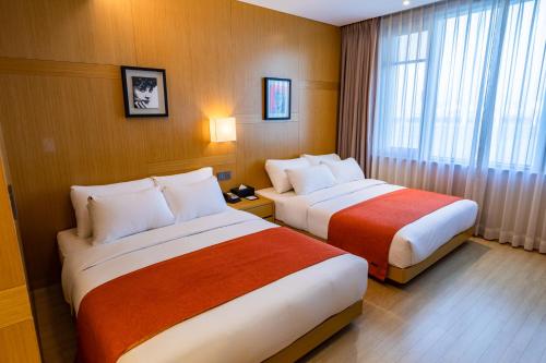 a hotel room with two beds and a window at Gwangyang Lacky Hotel in Gwangyang