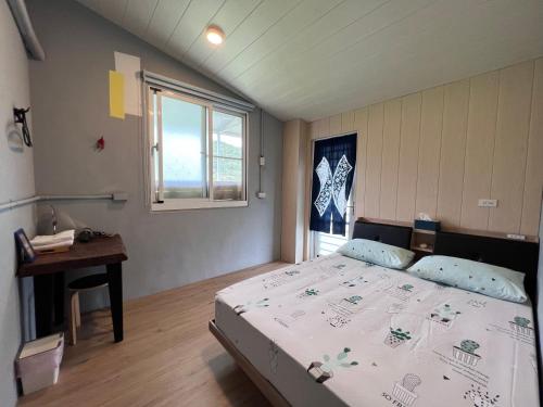 a bedroom with a bed and a desk and a window at 初衷民宿 臺東縣民宿1466號 in Taitung City