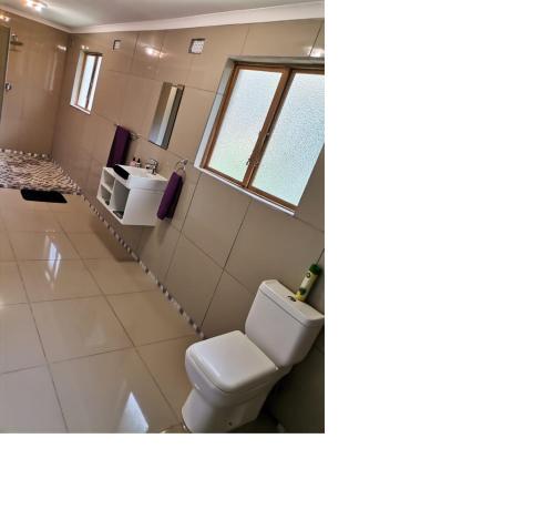 uma casa de banho com um WC e um lavatório em Pumula Holiday Home em Hibberdene