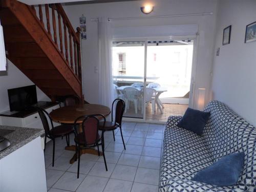 un salon avec un canapé et une table dans l'établissement Appartement cosy avec mezzanine, terrasse et garage près de la plage - 6 pers - FR-1-326-543, à Marseillan