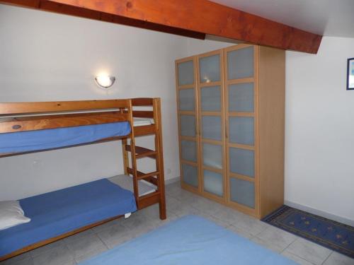 une chambre avec deux lits superposés et un placard dans l'établissement Appartement cosy avec mezzanine, terrasse et garage près de la plage - 6 pers - FR-1-326-543, à Marseillan